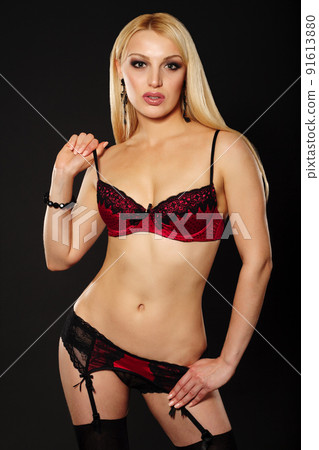 Beautiful Young Caucasian Woman, In Her Twenties, With Blonde Hair, Wearing Sexy Black Lingerie And Stockings, Isolated On black 91613880
