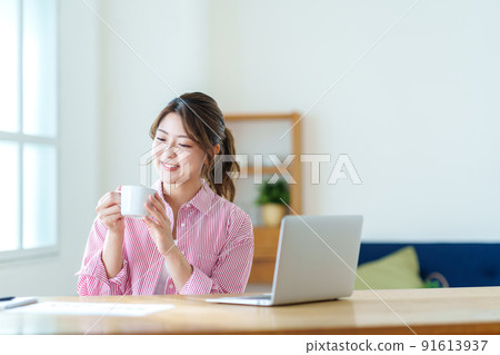 A young woman taking a break during telework. 91613937