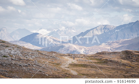 Hikers walking through stunning alpine valley in Canadian Rockies during fall,Jasper N.Park,Canada Hikers walking through stunning alpine valley in Canadian Rockies during fall,Jasper N.Park,Canada 91614690
