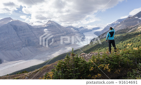 Male hiker overlooking untouched alpine valley with glacier on its end, Jasper, Canada 91614691