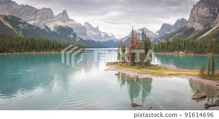 Island of trees in the middle of turquoise alpine lake surrounded by mountains,pano,Jasper NP,Canada 91614696