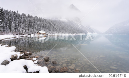 Almost frozen azure alpine lake shrouded by fog in early winter, Banff N. Park, Canada Almost frozen azure alpine lake shrouded by fog in early winter, Banff N. Park, Canada 91614748