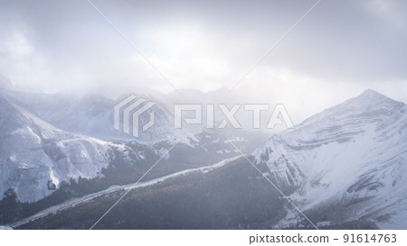 High alpine road leading through big mountains covered by snow, winter scenery, wide, Canada 91614763