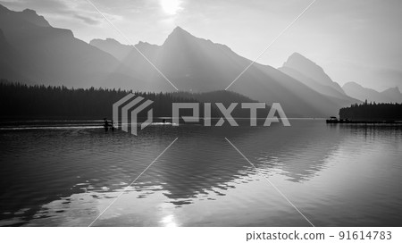 Mountains and sun reflecting in still alpine lake, monochromatic, Jasper NP, Canada 91614783