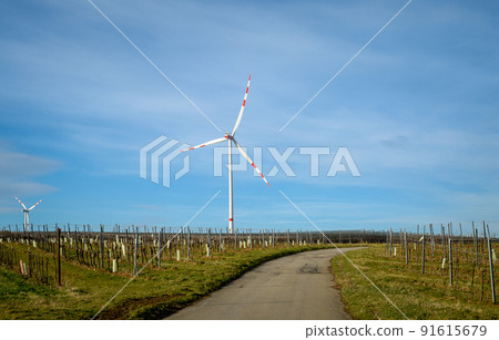 Windmills farm on a large field spinning in the day against blue sky. Alternative energy concept. Windmills farm on a large field spinning in the day against blue sky. Alternative energy concept. 91615679