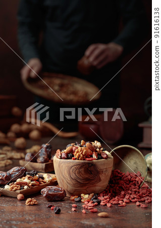 Various dried fruits and nuts on a kitchen table. 91616138
