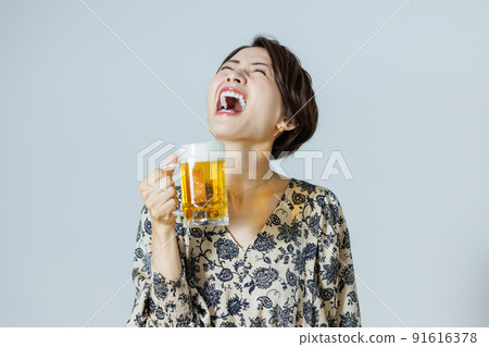 A woman drinking beer with a mug A woman drinking beer with a mug 91616378