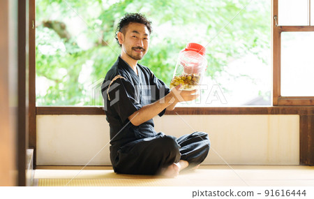 A bearded man looking at the brewed plum wine A bearded man looking at the brewed plum wine 91616444