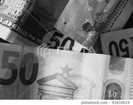 Paper banknotes in denominations of 50 dollars and 50 euros, a close-up shot. Black and white image. Paper banknotes in denominations of 50 dollars and 50 euros, a close-up shot. Black and white image. 91616628