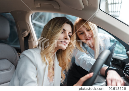 Car dealership consultant showing the interior of the car to a client. Car dealership consultant showing the interior of the car to a client. 91618326