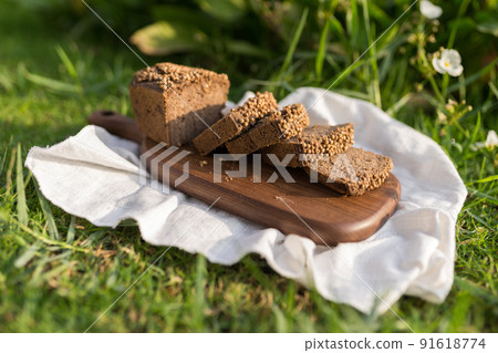Composition of homemade custard bread on wood board with white cloth napkin on the green grass. High quality photo 91618774