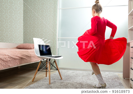 Little dancer in a red latin dance dress dances at home, learns to dance remotely. Dance lessons at home. Dance lessons online Little dancer in a red latin dance dress dances at home, learns to dance remotely. Dance lessons at home. Dance lessons online 91618973