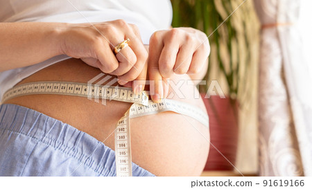 Measure body pregnancy woman. Happy beautiful pregnant woman with tape measuring belly. Concept of pregnancy, maternity, expectation for baby birth. 91619166