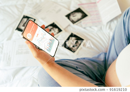 Pregnancy app. Mobile pregnancy online maternity application. Pregnant mother using phone. Pregnancy, medicine, pharmaceutics, health care and people concept. 91619210