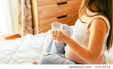 Drinking water pregnant woman. Young pregnancy mother drink water. Pregnant lady waiting of baby. Glass of water. Concept maternity, childbirth. 91619238
