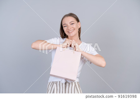 Cheerful beautiful girl holding shopping bag with place for mock up isolated Cheerful beautiful girl holding shopping bag with place for mock up isolated 91619398
