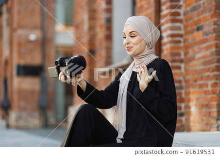 Arab girl takes pictures of herself on camera. Arab girl takes pictures of herself on camera. 91619531