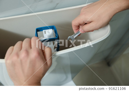 Professional plumber repairing toilet in bathroom, closeup 91621106