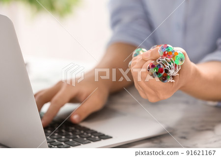 Woman squeezing colorful slime in office, closeup. Antistress toy Woman squeezing colorful slime in office, closeup. Antistress toy 91621167