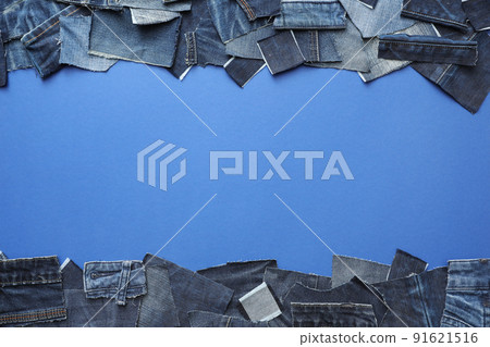 Frame made of cut jeans on blue background, top view. Space for text 91621516