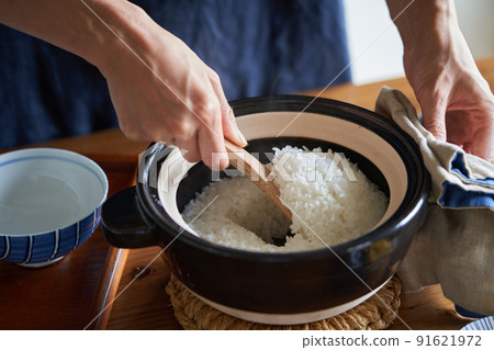 Mix rice cooked in a clay pot with a rice scoop Mix rice cooked in a clay pot with a rice scoop 91621972