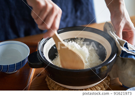 Mix rice cooked in a clay pot with a rice scoop Mix rice cooked in a clay pot with a rice scoop 91621973