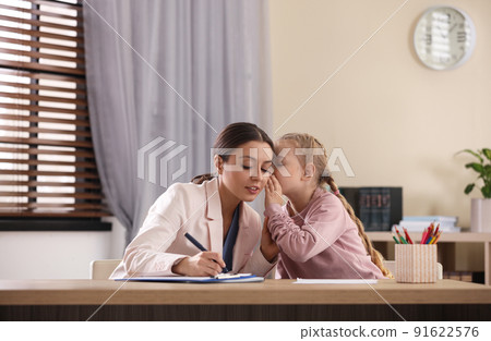 Child psychotherapist working with little girl in office 91622576