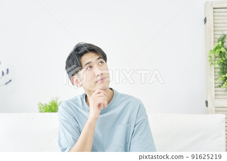 A man thinking in the living room 91625219