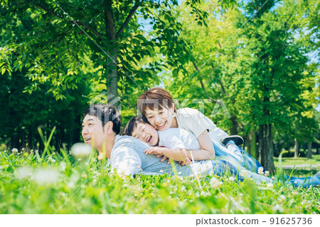 Parents and children lying on the meadow 91625736