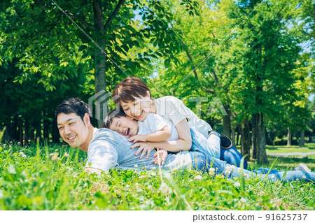 Parents and children lying on the meadow 91625737