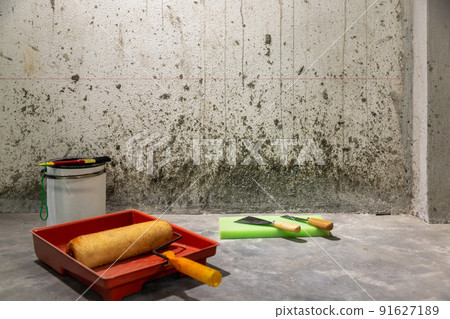 Renovation home , Painter scraping concrete debris on wall from pour new concrete layer over old floor. 91627189