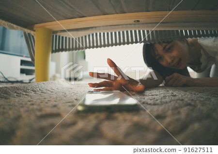 A woman who found a smartphone under the bed A woman who found a smartphone under the bed 91627511