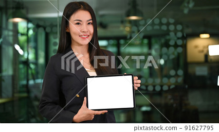 Beautiful Asian businesswoman holding a blank screen tablet mockup 91627795
