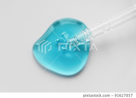 Pipette with blue gel, transparent fluid hyaluronic acid. Cosmetics, science and healthcare concept closeup. Dose of retinol. Front view, high angle shot. Beauty product closeup, banner 91627857