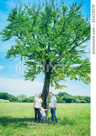 三個父母和孩子在樹下排隊 91628976