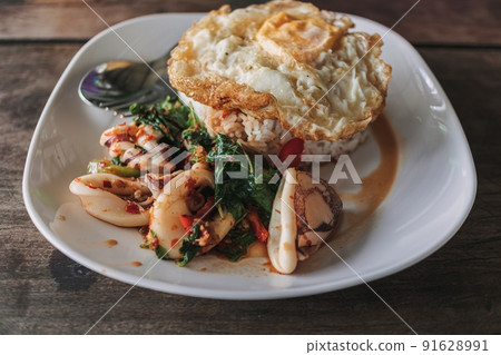 Thai Rice topped with stir-fried squid and basil. Thai Rice topped with stir-fried squid and basil. 91628991
