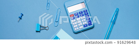 Calculator, stationery accessories on blue background with copy space. Look Calculator, stationery accessories on blue background with copy space. Look 91629648