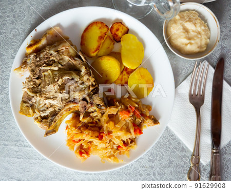 Juicy pork with potatoes and stewed cabbage Juicy pork with potatoes and stewed cabbage 91629908