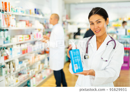 Female pharmacist with sanitizer in drugstore Female pharmacist with sanitizer in drugstore 91629931