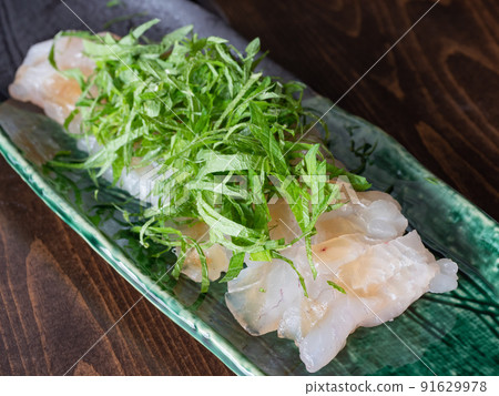 Sea bream sashimi tightened with kelp. Topped with perilla. 91629978