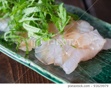 Sea bream sashimi tightened with kelp. Topped with perilla. 91629979