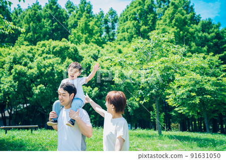 Parents and children playing while piggybacking in the park Parents and children playing while piggybacking in the park 91631050