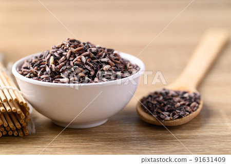Thai purple rice seed in bowl with spoon on wooden background, Organic rice grain Thai purple rice seed in bowl with spoon on wooden background, Organic rice grain 91631409