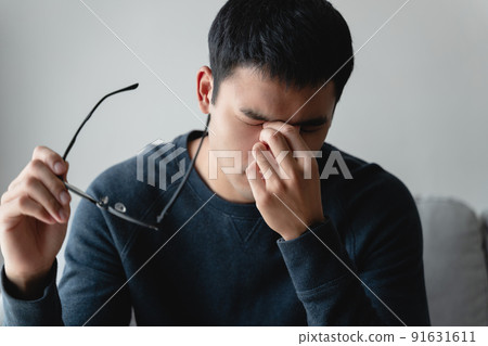 stressed man take off glasses massage eyes feel fatigue suffering from headache, exhausted man having eyestrain or astigmatism with overwork. 91631611