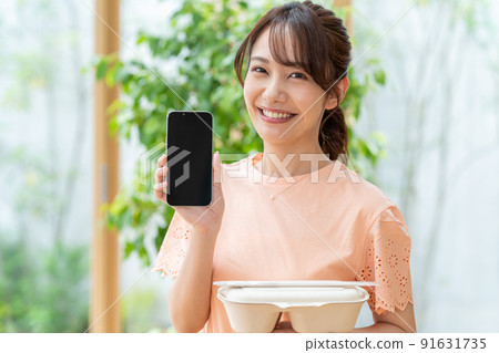 Young woman with lunch and smartphone Young woman with lunch and smartphone 91631735