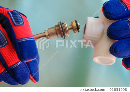 Male hands holding detail of heating radiator Male hands holding detail of heating radiator 91631908