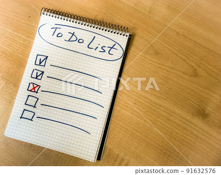 to do list checklist hand written on notepad paper lay on wooden table. to do list checklist hand written on notepad paper lay on wooden table. 91632576