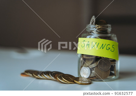 saving money concept. glass jar full of coins. Image with selective focus saving money concept. glass jar full of coins. Image with selective focus 91632577