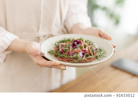Woman holding a plate of pasta Woman holding a plate of pasta 91633012