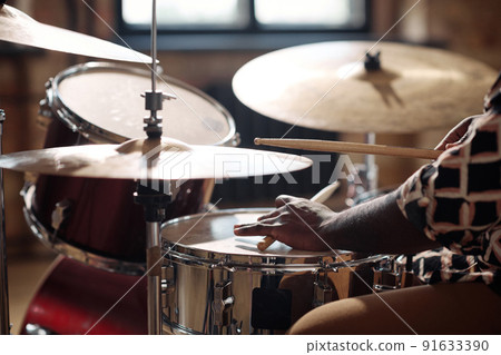 Close-up of African drummer playing rock music on drums set with sticks 91633390